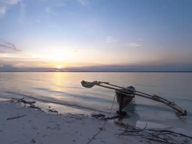 Ngalawa sur le sable face au lagon de la côte Nord de Zanzibar au coucher du soleil