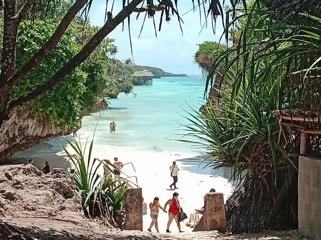 Petite crique secrète à Zanzibar bordée de falaises, sable blanc et lagon turquoise