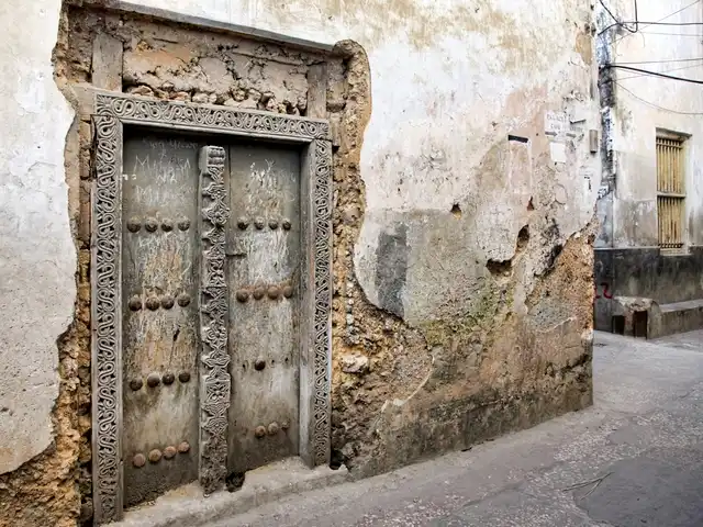 Porte ancienne en bois sculpté à Stone Town, maison traditionnelle en pierre de corail